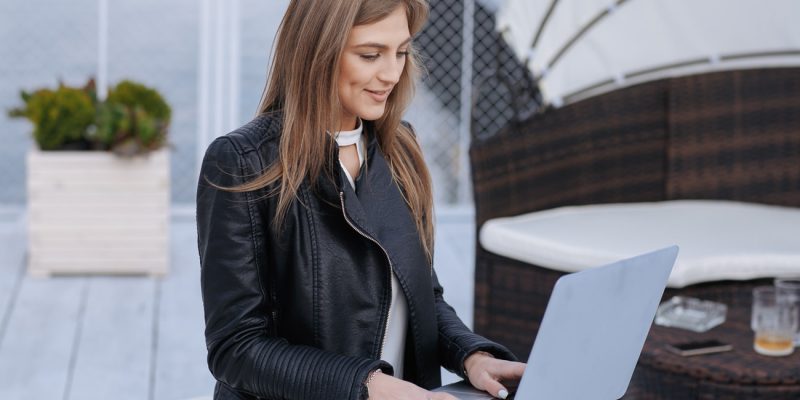 woman-with-seaport-background-with-laptop-her-legs